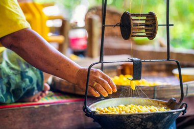 El sanatları ve işçilik. İpek iplikler için ipek yetiştirme. Tekstil dokuma ustalığında iplik bükme makinesi. Dokuma ve döndürme kadın eli Doğal renkli iplikler ya da iplik.