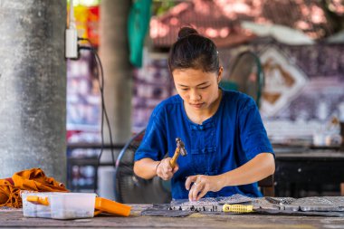 Silverware making. Thai craftman are making silverware. The original of the silver craftsmen on Wua Lai road, Chiang Mai. Thailand. clipart