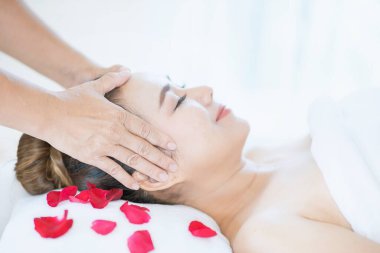 Ellerini başının üstüne koy. Yüz masajı, spa masajı, spa salonunda rahatlatıcı yüz masajı. Genç ve güzel bir kadın spa güzellik kliniğinde kafa masajı yapıyor..