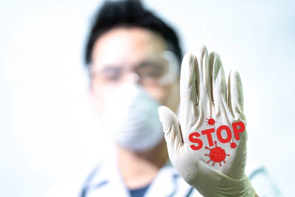 Stop COVID-19 concept. The male doctor is making a stop sign to stop the virus by hand. Doctors holding Coronavirus 2019-nCoV Stop that cause mysterious viral in China (Wuhan City)