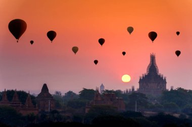 Bagan, Myanmar 'da bir sürü sıcak hava balonu doğuyor. Bagan tarihi Budist tapınakları ve aptalları olan eski bir tapınaktır. Pagoda depremden sonra tamir ediliyor. Metin için boşluk.