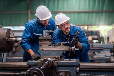Mühendisler ve yetenekli teknisyenler makineleri koruyor. Mühendisler endüstriyel alanda çalışıyor ve makineleri tamir ediyorlar. Elinde kerpeten tutan teknisyen. Metal Vernier kalibresini ölçekle.