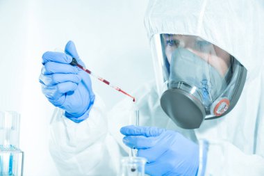 Bilim insanları virüsü aramak için laboratuardaki cam bir tüpün içine kan döküyorlar. Coronavirüs 2019, Covid19.