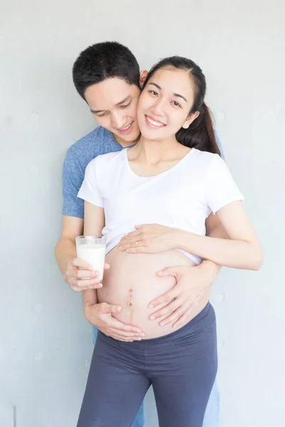 아버지는 어머니들을 유리로 우유를 준비하고 아시아인 아버지는 임산부를 돌봅니다 원문을 — 스톡 사진