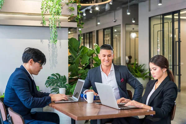 Co-working space concept. Businessman and Businesswoman is brainstroming in a co working space. Company employees are sitting in front of laptop computers.