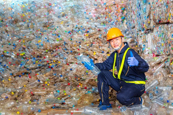 Recycle employees wearing protective clothing are working in recycling plants. Foreman showing thumbs up on Forklifts in the Industrial recycle. Used plastic bottles.