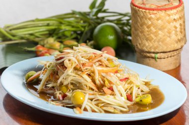 Yengeç ve turşulu Papaya salatası, mayalanmış balık soslu Papaya salatası, ahşap masada yengeç nükteli pirinç..