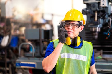 Sektörde çalışan bir mühendisin portresi. Foreman iletişim kurmak için telsizle çalışır. Profesyonel teknisyenler telsizle çalışır. Makineleri olan fabrikalarda