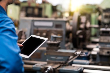 Seçici odaklanma. Profesyonel teknisyenler makinenin sistemini tabletle kontrol ediyorlar. Mühendisler ve yetenekli teknisyenler makineleri koruyor..