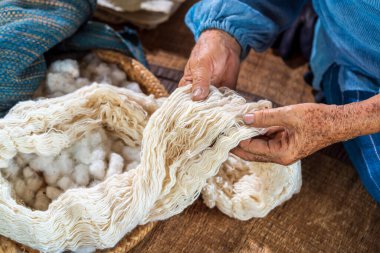 Tayland çivit pamuğunun ustaları. Yaşlı bir kadın pamuktan yapılmış ipliği inceliyor. Yerel usta Sakon Nakhon bölgesinin orjinal Indigo Cotton Weaver 'ıdır..