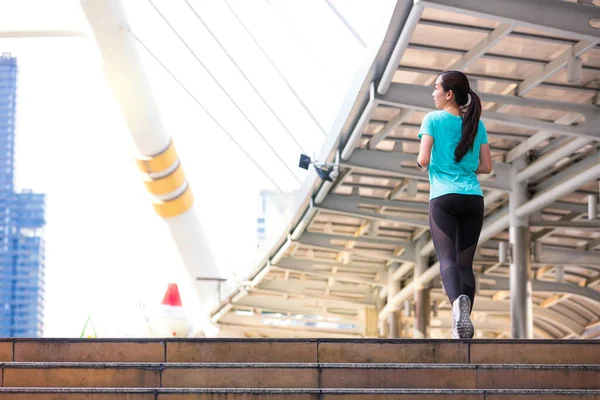 Fitness female on morning workout. Asian female runner running. young woman running up stairs.