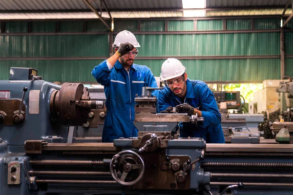 Mühendisler ve yetenekli teknisyenler makineleri koruyor. Mühendisler endüstriyel alanda çalışıyor ve makineleri tamir ediyorlar. Elinde kerpeten tutan teknisyen. Metal Vernier kalibresini ölçekle.