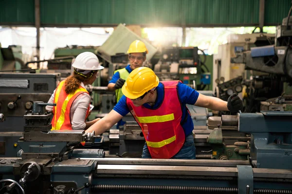 An expert technician is inspecting industrial machinery in a steel factory. Engineers are working and repairing machines in industrial. Technician holding Measuring pliers.