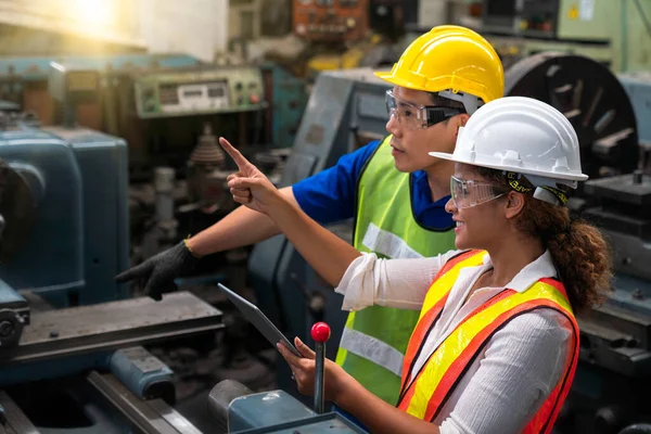 Asian men and African American women are working in industrial plants. Hold the tablet in your hand to see how the machine works.