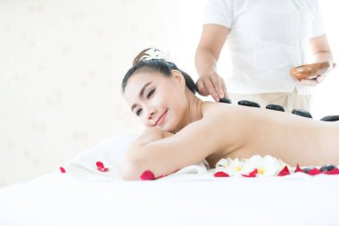 Genç bayan spa odasında spa masajı yapıyor. Sıcak taşlı spa. Tayland Spa 'sı.