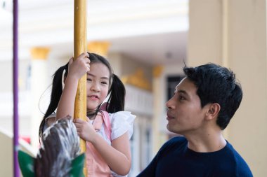 Baba ve kızı lunaparkta oynuyorlar.