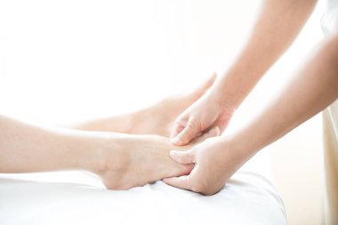 Ayak masajı. Terapistin kadın ayağına yaptığı masajı kapat. Sağlık kaplıcasında Asyalı bir kadın gerekli yağla aroma terapisi masajı yaptırıyor. Tayland. Boşluğu kopyala.