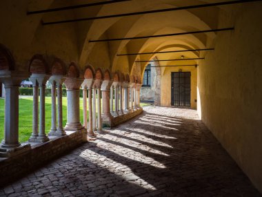 Sundurma bir Benedictine abbey avlusunda beyaz taş sütunlar ile.