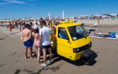 Sottomarina, İtalya - 23 Haziran 2018: Meyve satıcı ile sahilde üç tekerlekli sarı araç.