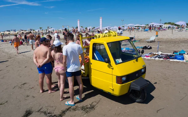 Sottomarina, İtalya - 23 Haziran 2018: Meyve satıcı ile sahilde üç tekerlekli sarı araç.