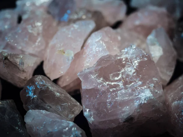Macro mineral stone Pink quartz on black background close up