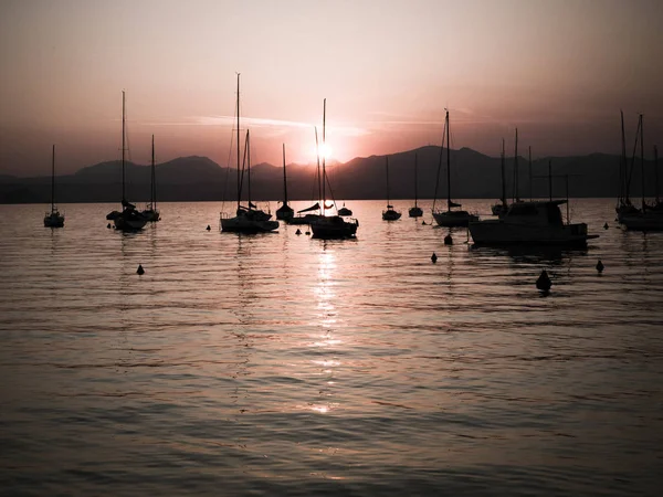 Lake Garda için yapılan günbatımında demirleyen Yelkenliler.