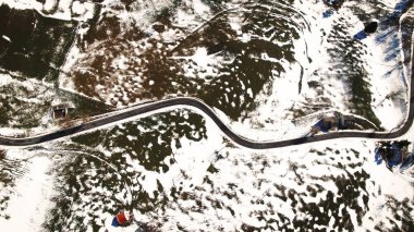 Yol rüzgarlar ile kısmen karla kaplı tepeler.