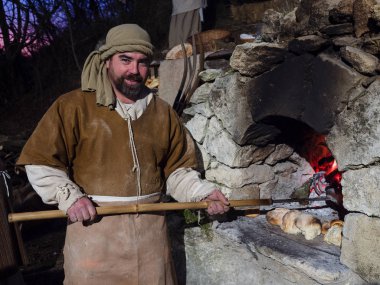 Vicenza, İtalya - 30 Aralık 2017: Baker yapmak ekmek sırasında bir tarihi yeniden yürürlüğe girmesi mağaraları Villaga, İtalya.