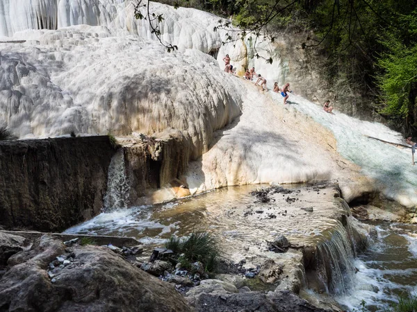 La gente riposa sulle cascate termali di sale della sorgente minerale — Foto Stock