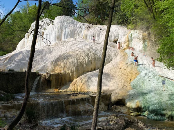 La gente riposa sulle cascate termali di sale della sorgente minerale — Foto Stock