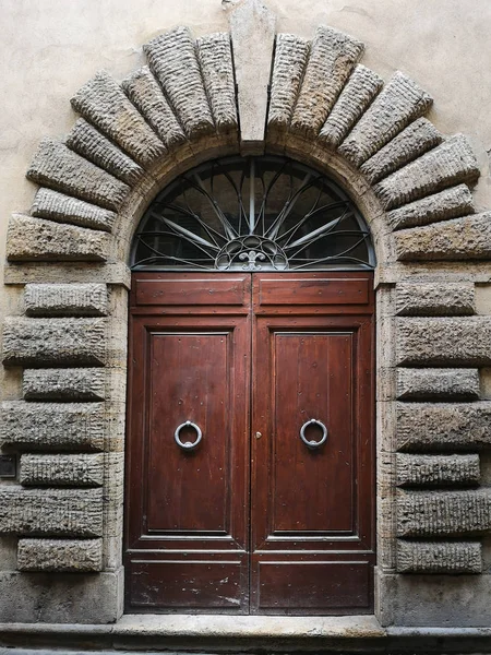 Ancient wooden portal with carved stone arch of an Italian medie — Stock Photo, Image