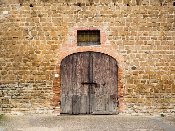 Ahşap portal ve pencere taş duvarda ızgara ile.