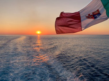 Gün batımında denize açılan bir gemiye İtalyan bayrağı sallanıyor.