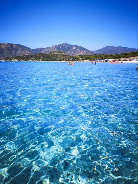 Het blauwe heldere water en het witte zand van een strand in Sardinië. — Stockfoto