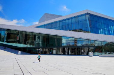 Neşeli küçük çocuk bina güneşli yaz sabah sırasında Oslo, Norveç Oslo opera önünde çalışır.