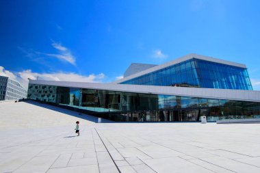 Neşeli küçük çocuk bina güneşli yaz sabah sırasında Oslo, Norveç Oslo opera önünde çalışır.