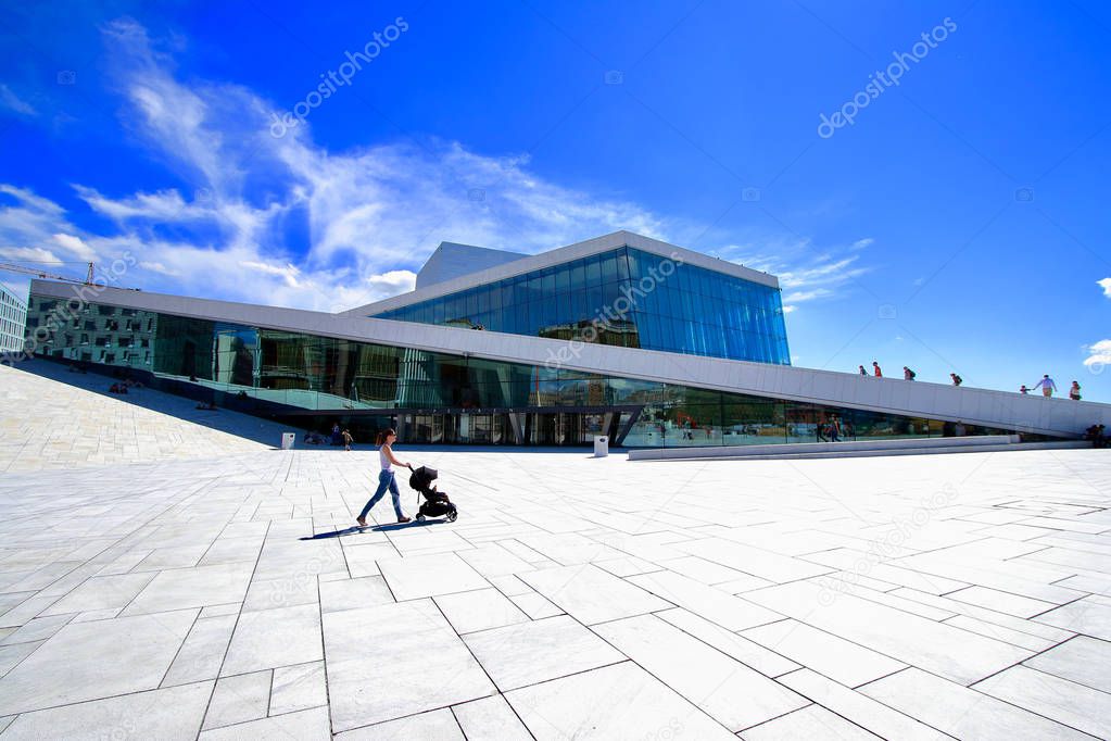 A young mother enjoying a walk through the Oslo opera building with her little baby relaxing in his baby carriage, Oslo, Norway.