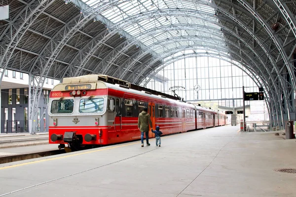 背景には ベルゲン ノルウェーの典型的な赤ヴォス鉄道とベルゲン鉄道駅プラットフォーム歩く若い母親と小さな子供 — ストック写真