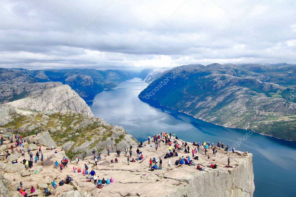 Several hikers enjoying the views in the summit of the Pulpit Rock (Preikestolen), one of the world's most spectacular viewing points . A plateau that rises 604 meters above the Lysefjord, Norway.