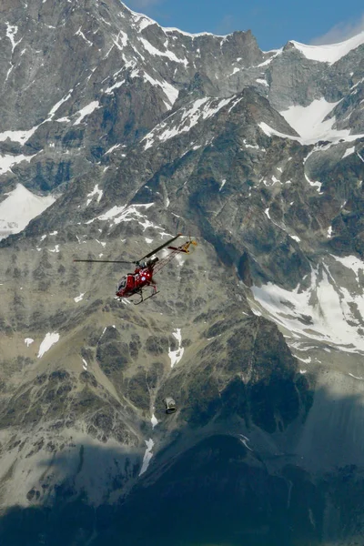 救援直升机在靠近瑞士采尔马特的马特霍恩和布雷索恩山峰附近的瑞士阿尔卑斯山行动 — 图库照片