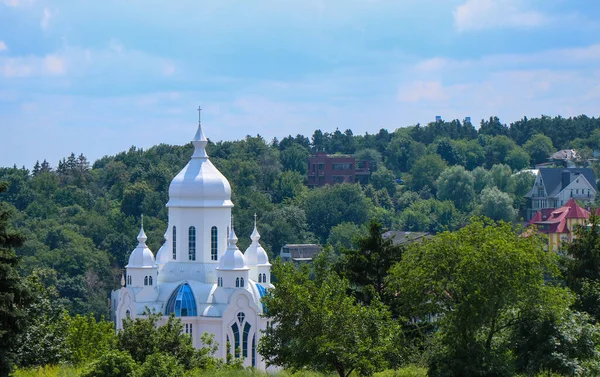 Ortodoks beyaz kilisesi ağaçların arasında