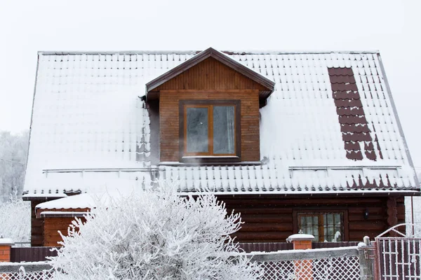 Snow-covered village house in winter landscape