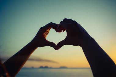 Kalp şeklinde eller. Kadın elleri kalp şeklinde soyut bir siluet.