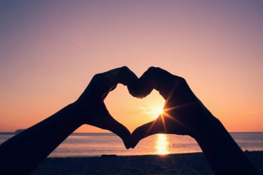 Kalp şeklinde eller. Kadın elleri kalp şeklinde soyut bir siluet.