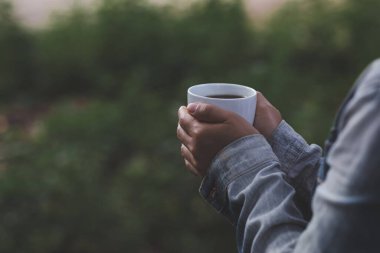 Yağmurlu mevsimde sıcak kahveyle rahatlatıcı manzara. Karanlık ton tarzı fotoğraflar. Metinler için boş alan.