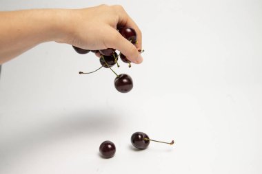 Tatlı kiraz çilek beyaz arka plan üzerinde bir elinde