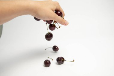 Tatlı kiraz çilek beyaz arka plan üzerinde bir elinde