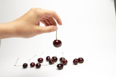 Tatlı kiraz çilek beyaz arka plan üzerinde bir elinde