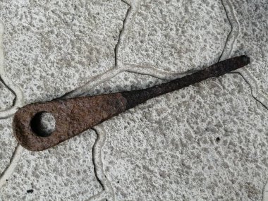 Taşların arkasında paslı bir tornavida var. Yirminci yüzyılın başındaki bu tornavida, uzun yıllar boyunca, üzerinde kalın bir pas tabakası oluştu.