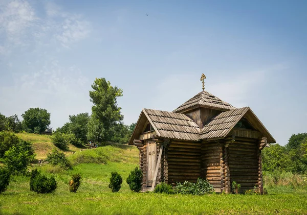 Eski pitoresk ahşap köy Şapel ve güneşli yaz çayır